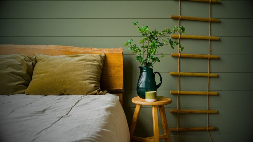 A bed with a wooden ladder and a plant on it. Bedding sheets add comfort and style into bedroom decor