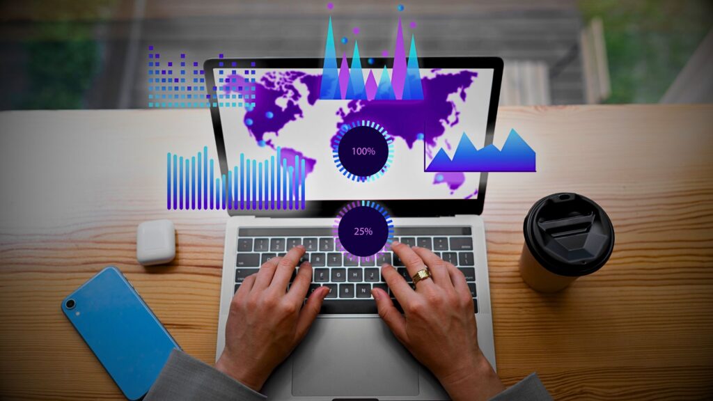 A person typing on a laptop with graphs displayed on the screen figuring data management